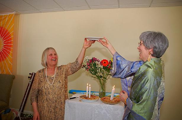 14 perfecthealth.jpg - Leanne de Freitas, wife of Raja Graham, and local Teacher of Transcendental Meditation cut the celebration cake and make wishes for the health and happiness of the members of the Maharishi Peace Palace and all the citizens of Minnesota.